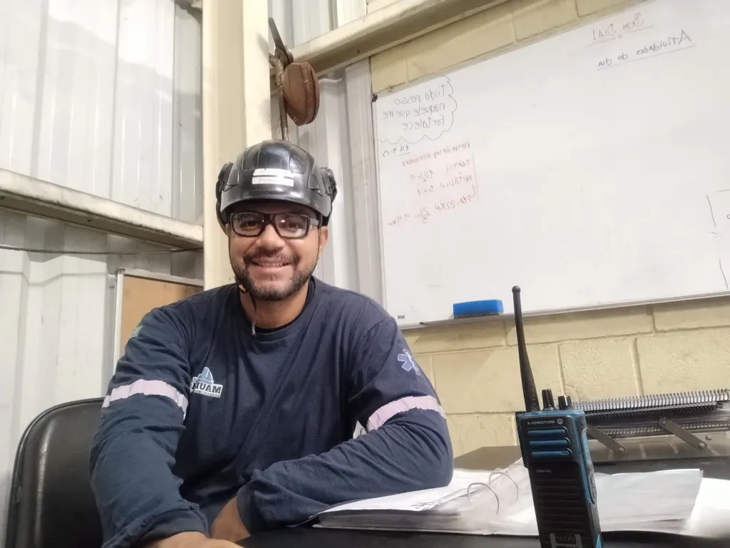 Maurício, fundador da MaulehSeg, sorrindo em sua mesa de trabalho