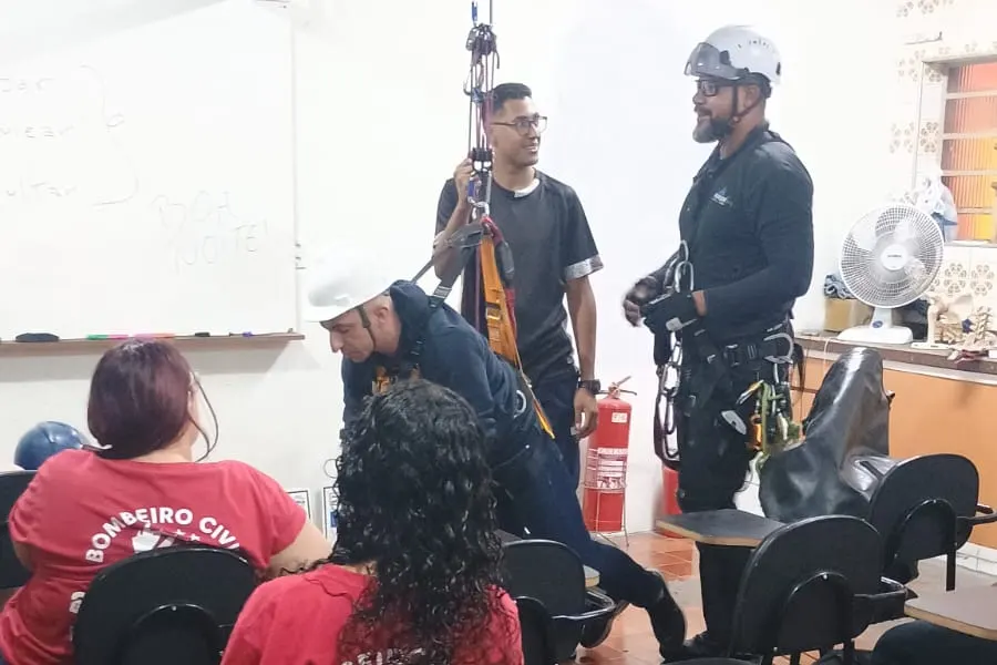 Turma de brigadistas em sala de aula acompanhando a demonstração de dois instrutores
